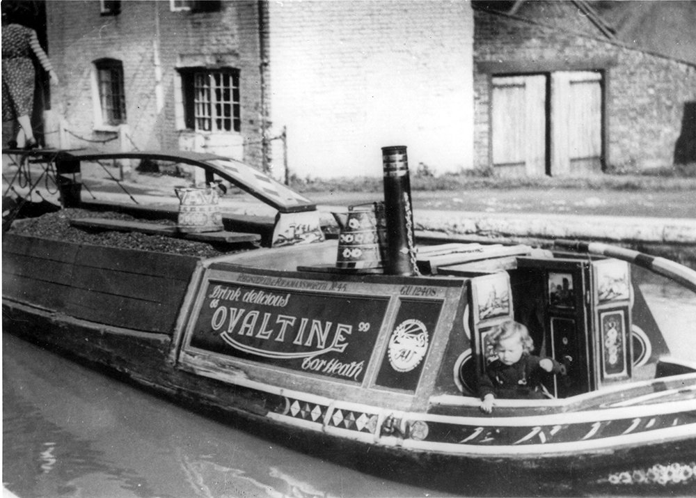 A young girl at the stern of the very well-loaded Ovaltine butty Enid at Hawkesbury Junction..